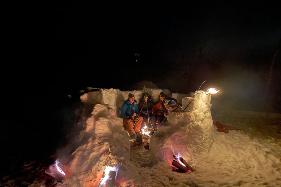 Mensen bij het kampvuur in de sneeuw